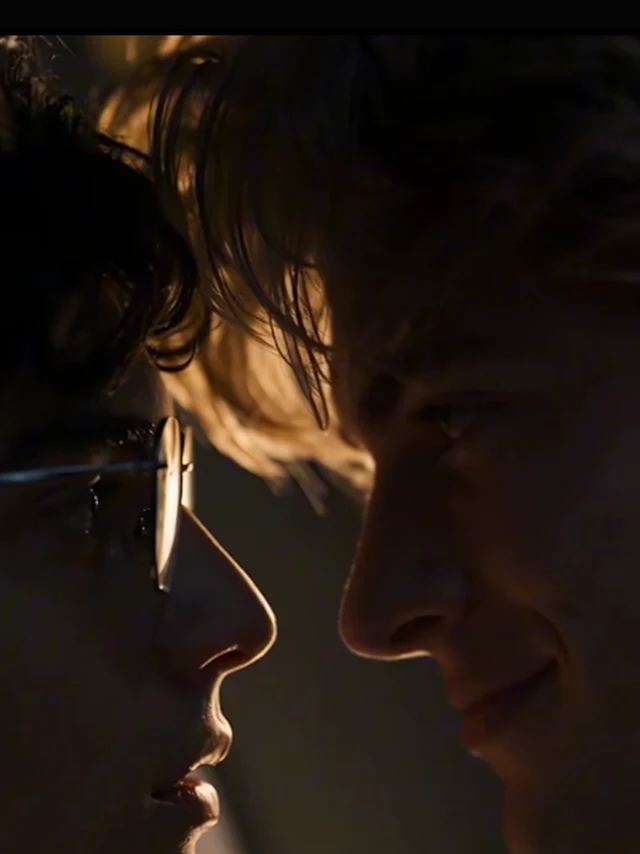 The Secret Critic Beside Me key art — the near-touch: two faces close enough to kiss in the warm dark, glasses catching the rim light (key art derived from the episode-10 as-aired hero frame: 3:4 full-top window, main-threshold white-band scan zero hits re-verified inline, window recorded in the sourcing ledger only)
