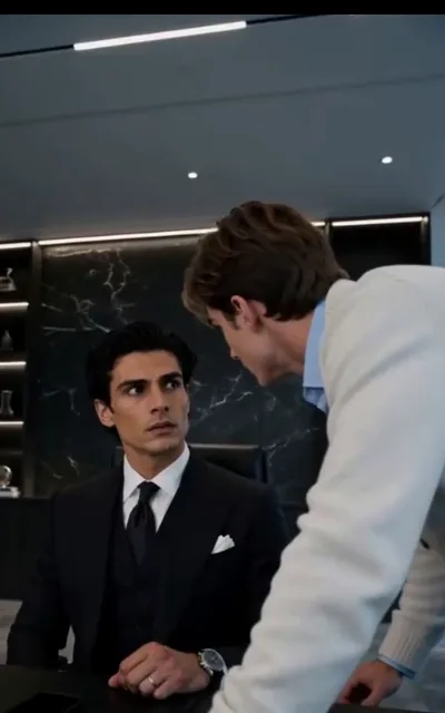 First contact in the corner office — Adrian looks up from the chair, Noah leans in over the desk; the confrontation starts professional (ep5)