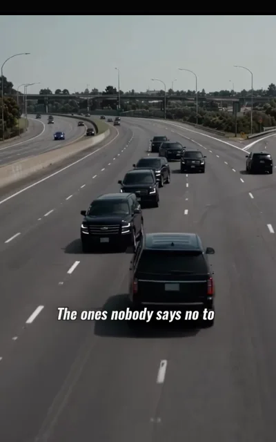 The motorcade — a line of black full-size SUVs rolling down a daylight highway, streetlights and an overpass beyond, the caption The ones nobody says no to beneath (ep5; subtitles as aired — power-declared frame, no people in shot)