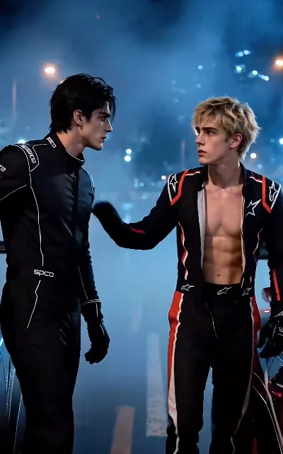 The paddock standoff — Cole in black against Jesse’s open collar, the rivalry nose to nose before it becomes anything else (ep1)