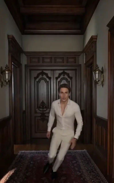 The walk - a man with dark-brown short hair in a fitted cream shirt with an open collar walking down a long wood-paneled gallery lined with brass sconces and a wine-red runner (ep6; movement beat - the estate gallery, male-lead scene line)