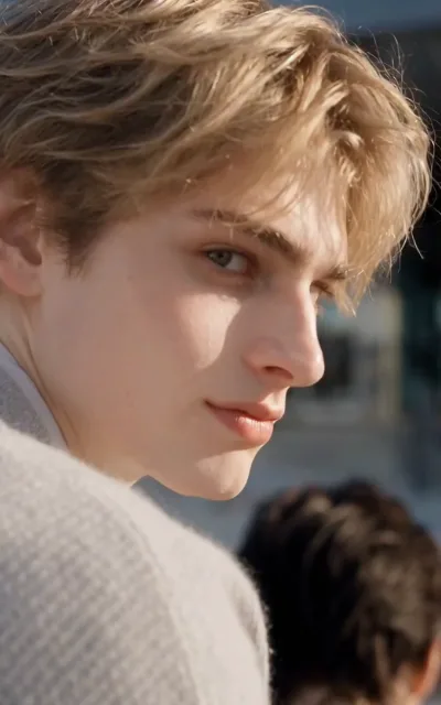 Noah's golden curls catch warm light as he glances aside with a faint smile