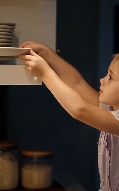 Frame ep01-f00 from episode 1 — Lily reaching up to set plates (ep1; subtitles as aired — Today is Dad's birthday.)