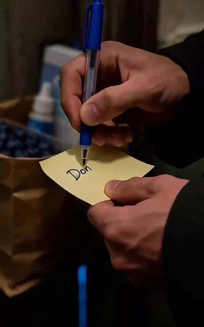 Frame ep02-f02 from episode 2 — A sticky note being written on (ep2; subtitles as aired — Don.)