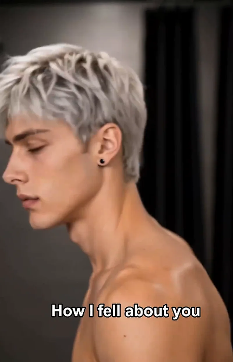 Side profile of Dylan (silver hair, bare shoulders, eyes closed) with a soft expression, subtitle reads 