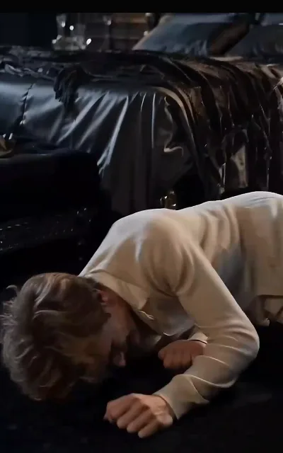 Eli kneeling, strength gone, holding himself together inside the mansion’s cold geometry — the toll the marriage takes, staged exactly as shot (ep3; distress frame as aired, not amplified)