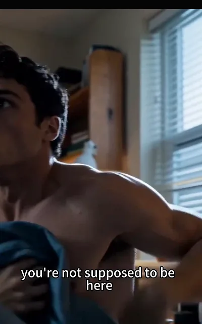 Kael shirtless mid-change, the warning delivered over his shoulder — "you're not supposed to be here", the boundary drawn the moment the secret gets a witness (ep2, subtitles as aired; shirtless-changing frame as aired, not amplified — dorm-room everyday context)