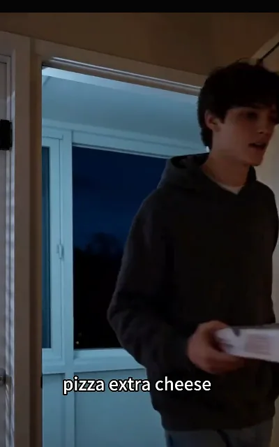 Liam at the door at night with a pizza box — "pizza extra cheese" — the ordinary warmth the show threads between its secrets (ep4, subtitles as aired)