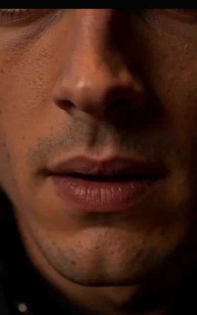 A lower-face close-up in half-light — stubble, lip and skin detail carrying the tension of the episode’s late stretch, staged exactly as shot (ep5)