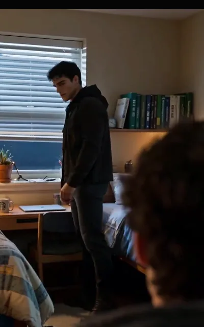 Kael standing in the dorm’s full frame, moody and still — the arc’s weight held in one composition (ep7)