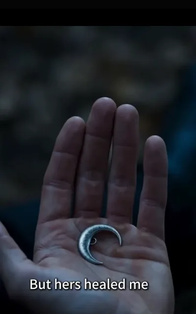 The crescent-moon pendant — a delicate gold locket resting in her palm, the family crest catching the lamplight — “But hers healed me” (ep2; subtitles as aired; prop anchor frame, not amplified; fated-mate moon prop)