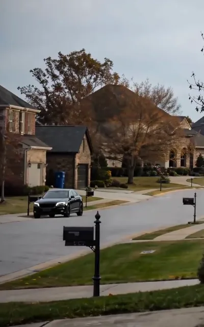 The suburb itself — quiet lawns, long shadows, the whole premise in one frame (ep4)