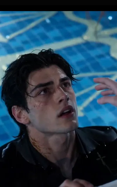 The pool edge — the dark-curly man soaked through, water beading his hair and face, scrapes at cheek and neck, chin lifted with red-rimmed eyes while a blurred hand reaches toward him from the corner (ep3; violence-context frame as aired, not amplified — vulnerability aftermath, no contact shown)