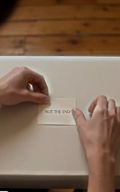 Episode 2 frame: a card reading 'NOT THE END' — the plot-turn anchor, hope-after-heartbreak signal