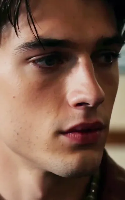 A young man's close-up, wet-haired and caught mid-thought — the campus supporting cast of the opening arc