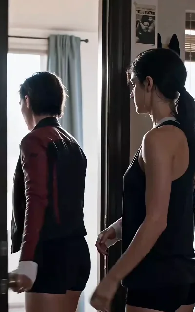 The goodbye at the door — one hand on the handle, white wraps still on, the other watching her go (ep4)