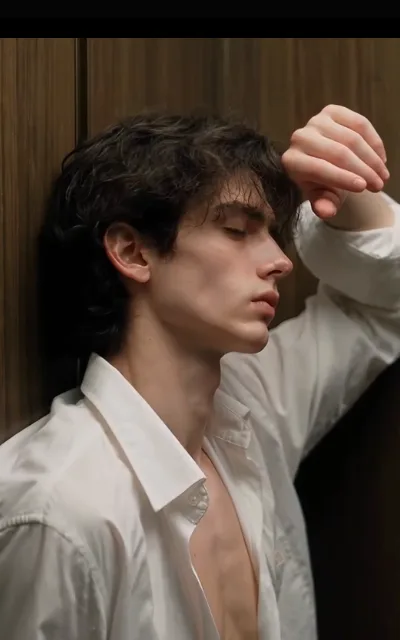 Elias at rest against the wood paneling — eyes closed, arm thrown across his brow, white shirt loose at the collar, warm side-light (ep1; atmosphere beat)