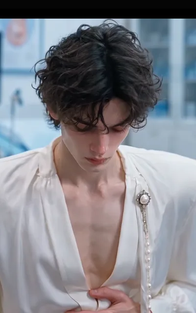 Elias in the cool light — lashes down, ivory satin V-neck, vintage pearl brooch at the lapel, one hand resting at his chest (ep6; source of avatar_elias, single-base anchor; zero-subtitle portrait)