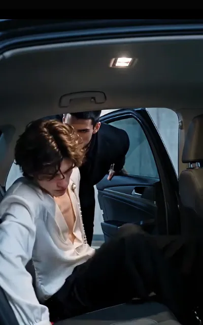 The car door — Elias slumped low in the back seat, pearls at his collar, Dante in black leaning in after him, one hand on the door frame (ep7; atmosphere beat)