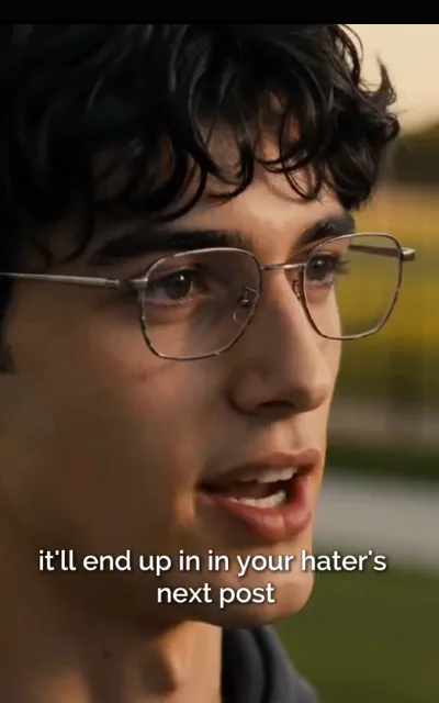 The warning tease — curly hair, silver frames, dusk grass bokeh behind — “it’ll end up in in your hater’s next post” (ep5; meme form as aired, not amplified; station caption as aired — the duplicated “in in” is the station’s own typo, kept uncorrected)