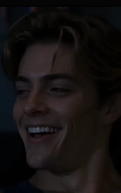 The full laugh — head tipped back into the dark, eyes bent shut, every tooth showing (ep8; atmosphere beat)
