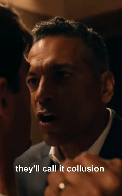 "they'll call it collusion" — a dark-skinned man in a tailored suit, gold ring emphasized mid-sentence: the fixer explaining how the trap will be labeled (ep5, subtitles as aired; he stays unnamed; conspiracy context)
